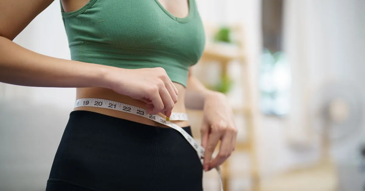 Close-up of woman measuring waist for medical weight loss in Rockwall, TX